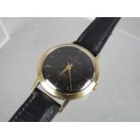 A gentleman's, yellow metal, Smiths Imperial wristwatch with black dial and 19 jewel movement,