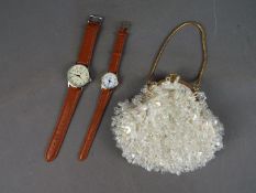 Two wristwatches, a lady's and a gentleman's, on brown leather straps and a purse.