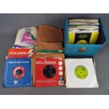 A collection of 7" vinyl records, 1 carry case and a bag, including John Lennon, Motown,
