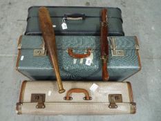 A vintage wood and brass carving set and a vintage exercise club and three vintage suitcases.