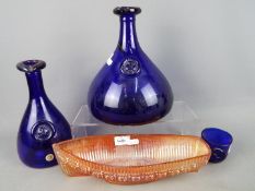 Three pieces of Kastrup-Holmegaard cobalt blue glass and a carnival glass model of a boat.