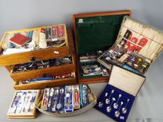 A large quantity of souvenir collector spoons and storage chest of drawers.