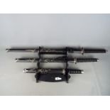 A set of three reproduction Japanese swords, longest approximately 101 cm,