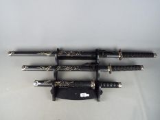 A set of three reproduction Japanese swords, longest approximately 101 cm,