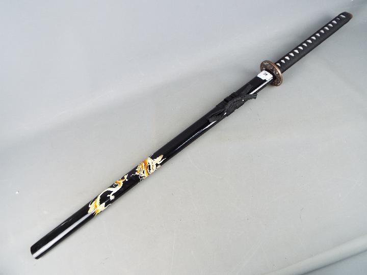 A reproduction Japanese sword with black lacquered, dragon decorated saya and dragon tsuba, - Image 4 of 4