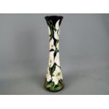 Moorcroft Pottery - a tall vase of waisted form decorated in the Buckingham Orchid,