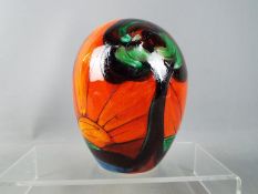 Anita Harris - an Art Deco style ovoid vase decorated with depictions of trees on an red / orange