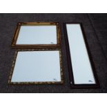 Three bevel edged wall mirrors of varying size.