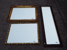 Three bevel edged wall mirrors of varying size.