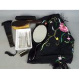 An ebony dressing table set comprising mirror and two brushes, paper fan,