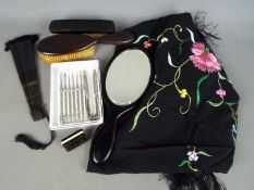 An ebony dressing table set comprising mirror and two brushes, paper fan,