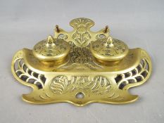 An early 20th century German brass inkwell / desk stand with pierced and floral decoration,