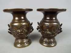 A pair of twin handled bronze vases, probably Japanese, with bird and turtle decoration,