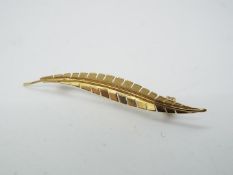 9ct gold - a 9ct gold bar brooch in the form of a leaf,