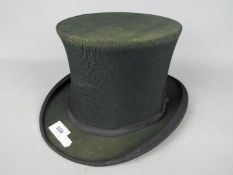 A Watson Prickard Ltd folding top hat, 15 cm (h), internal measurements approximately 7¾" by 6¼".