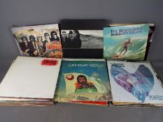 A large collection of 12" vinyl records to include The Traveling Wilburys, U2, The Beach Boys,