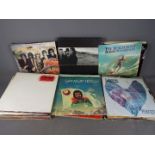 A large collection of 12" vinyl records to include The Traveling Wilburys, U2, The Beach Boys,