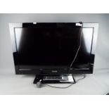 A Toshiba 32" flatscreen television, model 32BV702B with remote and instructions.