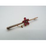 A 9ct gold, stone set, bar brooch in the form of a flower head, approximately 1.9 grams all in.