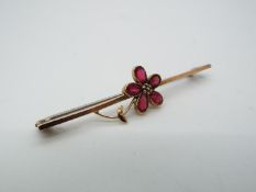 A 9ct gold, stone set, bar brooch in the form of a flower head, approximately 1.9 grams all in.