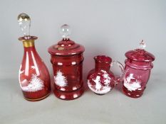 Four pieces of Mary Gregory type cranberry glass to include decanter, water jug and similar,
