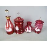 Four pieces of Mary Gregory type cranberry glass to include decanter, water jug and similar,