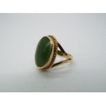 A 9ct yellow gold ring, stamped 9ct, set with cabochon green stone (2 cm x 1.