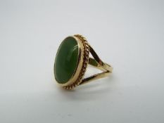 A 9ct yellow gold ring, stamped 9ct, set with cabochon green stone (2 cm x 1.