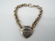 A belcher link charm bracelet with heart shaped charm stamped 'Please Return To Tiffany & Co.