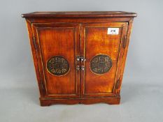 A small two-door cupboard of Asian decoration, approx 36.