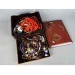 A Japanese lacquered box containing predominantly costume jewellery including bead necklaces,