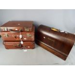 A vintage Singer sewing machine and three small vintage cases.