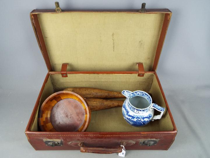 A vintage suitcase, a 19th century blue and white water jug,