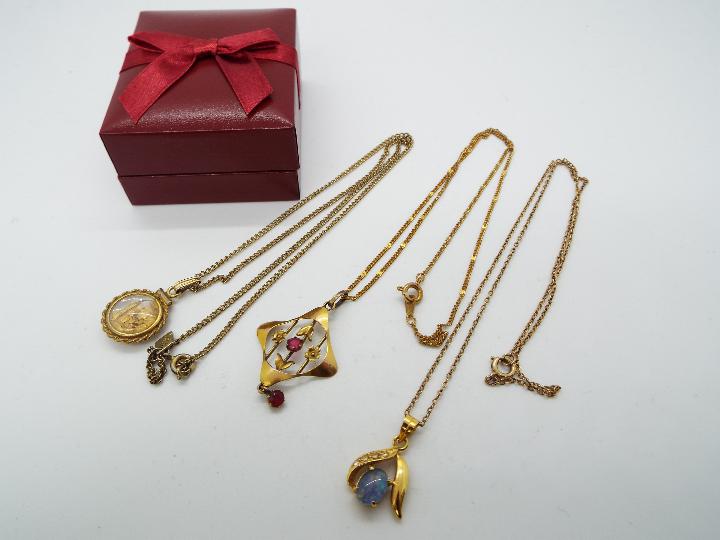 A yellow metal (unmarked) necklace with a 9ct gold pendant with stone set centre,