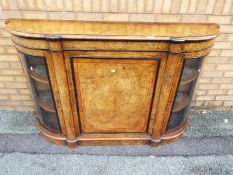 A burr walnut veneered credenza having central cupboard flanked by two glazed,