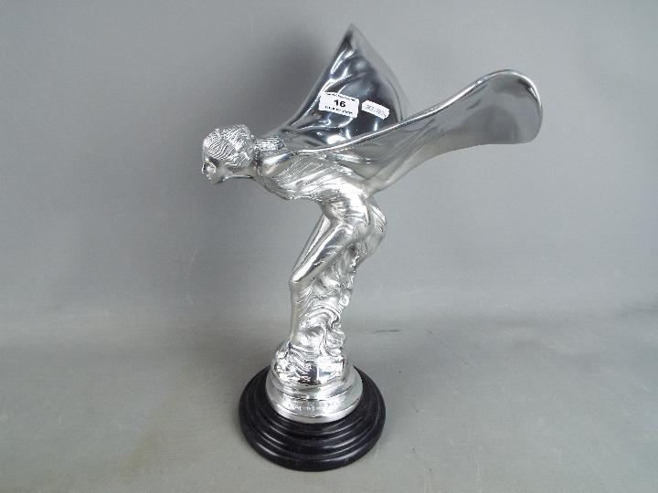 A large, white metal 'Spirit of Ecstacy' on marble base.