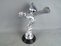 A large, white metal 'Spirit of Ecstacy' on marble base.