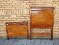 A bed frame with carved decoration, on castors.