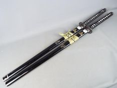 Two reproduction Japanese swords, each approximately 105 cm total length.