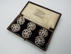 A set of six Art Nouveau, hallmarked silver buttons with scrolling floral decoration,