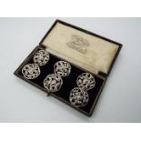 A set of six Art Nouveau, hallmarked silver buttons with scrolling floral decoration,