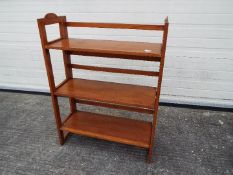 A vintage folding bookcase with three shelves,