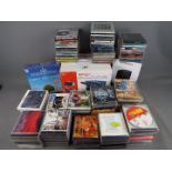 A box of CD's of varying genre, a Shinco portable DVD player,