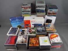 A box of CD's of varying genre, a Shinco portable DVD player,