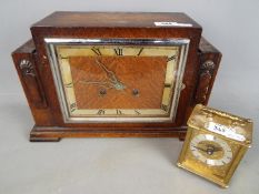 An oak cased mantel clock with Roman numerals to the dial,