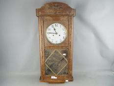 An oak cased wall clock with pendulum.