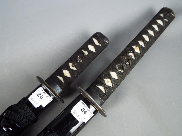 Two reproduction Japanese swords with black lacquered saya, longest approximately 109 cm. - Image 2 of 4