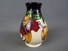 Moorcroft Pottery - a vase decorated in the Anna Lily pattern, printed factory label to the base,