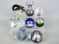 A collection of paperweights and a vase to include Caithness, Ekenas and similar.