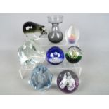 A collection of paperweights and a vase to include Caithness, Ekenas and similar.